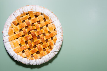 Tradition american apple pie with sugar crust top view on green background
