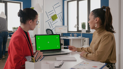 Business women working with green screen on laptop, using chroma key background with isolated mock...