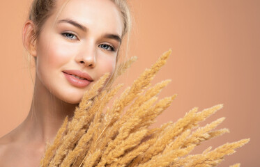 Naklejka premium Portrait of young smiling woman with a healthy skin of a face. Happy girl with a spring field flowers