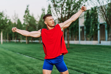 athletic man in red tank top posing outdoors fitness