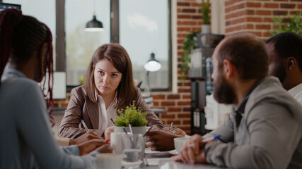 Close up of employee discussing project planning with workmates, brainstorming ideas for business strategy. Colleagues meeting to plan marketing strategy for company development.