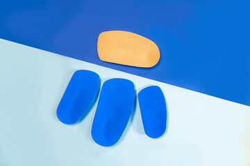 Foot support and healthy feet concept with orthopedic shoe insoles isolated on color background
