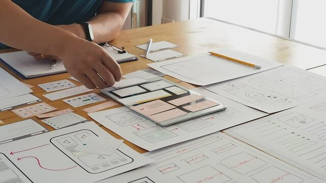 UX or UI designer designing application on tablet with mockup layout prototype.