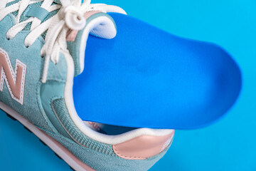 Orthopedic insoles for shoes on a colour background. Foot care