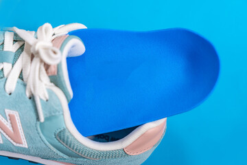 Orthopedic insoles for shoes on a colour background. Foot care