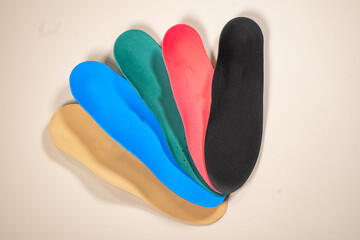 Orthopedic insoles for shoes on a colour background. Foot care