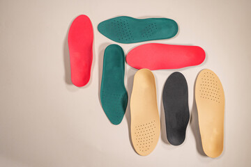 Orthopedic insoles for shoes on a colour background. Foot care