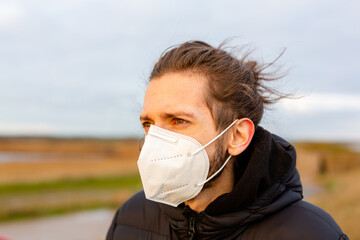 A young man wearing a KN95 one use facemask during the Covid-19 corona virus pandemic