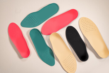 Orthopedic insoles for shoes on a colour background. Foot care