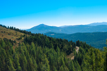 Bergige Landschaft in Österreich.  Blick von einem hochgelegenen Punkt auf  eine Gebirgskette. Sonniger Herbsttag