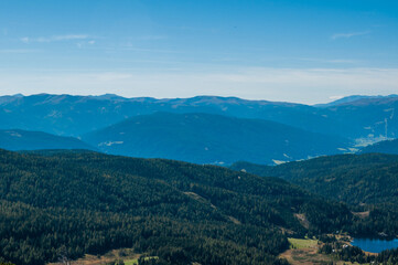 Fototapeta na wymiar Bergige Landschaft in Österreich. Blick von einem hochgelegenen Punkt auf eine Gebirgskette. Sonniger Herbsttag