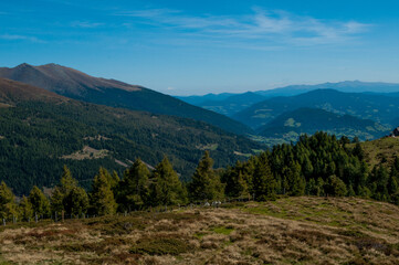 Bergige Landschaft in Österreich.  Blick von einem hochgelegenen Punkt auf  eine Gebirgskette. Sonniger Herbsttag