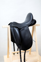Leather black horse saddle. Luxurious equestrian equipment object.