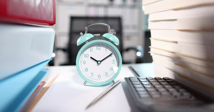 Alarm clock for ten in morning together with lot of documents on desktop