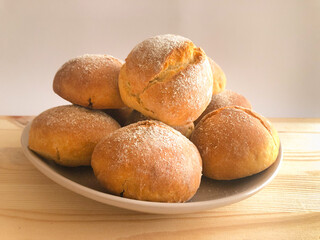 Traditional mini French wheat bun Petit Pain. Little buns for breakfast served in plate on wooden...