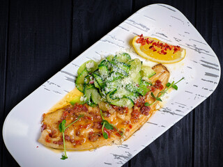 Trout fillet with sliced zucchini garnish served with grated Parmesan cheese. Restaurant Main dish on white plate on black wooden background. Healthy food. Ready to eat
