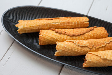 Wafer rolls with condensed milk. Thin and Crispy Waffle. Selective focus