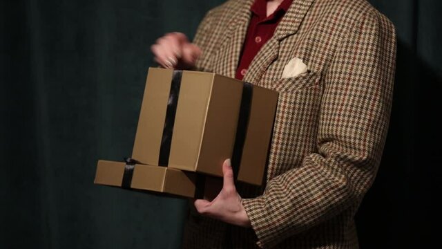 04 december 2021 - Wroclaw, Poland: Woman in blazer unpacks gift box with iPhone 12 on green background