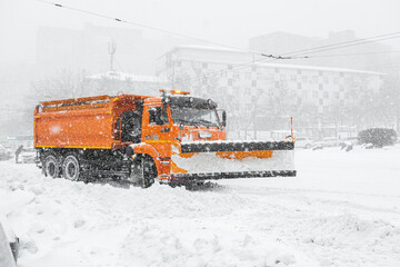 A large orange snowplow stands on the road before snow removal. Special equipment for snow removal cyclone.