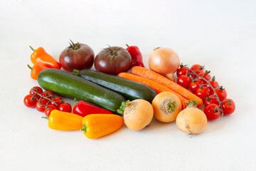 Bright raw vegetables on the white background
