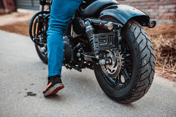Autumn season motorcycle on the road. The rubber protector of the rear wheel is new. Biker in jeans
