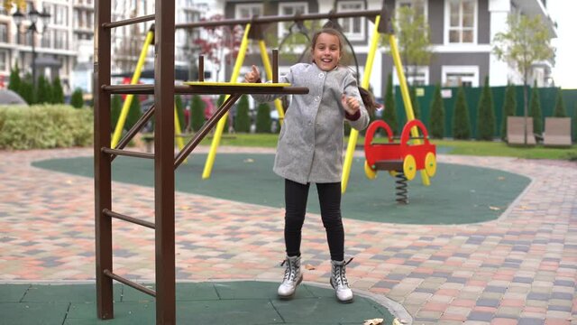 Little girl having fun playing on monkey bars