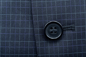 A button on a man's suit close-up. Element of men's clothing. Buttons