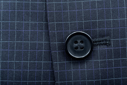 A button on a man's suit close-up. Element of men's clothing. Buttons