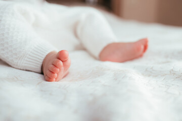 Bare baby feet on the bed close-up