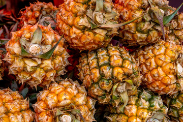 Ripe pineapple Victoria for sale at a market in Mauritius. Pineapple texture background.