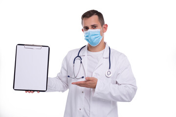 Doctor Man Showing Blank Clipboard Pointing at it Wearing Medical Mask Isolated. Advertisment, Office, Commercial Concept