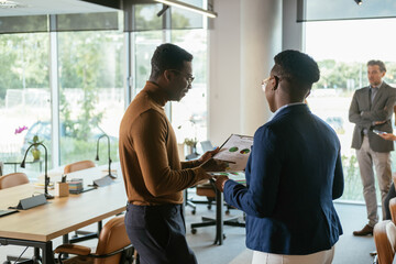 Business People Analyzing Pie Chart Together in Open Plan Office