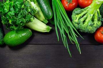 Fresh vegetables for cooking on a dark wooden background with space for text. Top view. Concept of healthy, vegetarian, diet food.