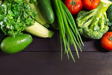 Fresh vegetables for cooking on a dark wooden background with space for text. Top view. Concept of healthy, vegetarian, diet food.