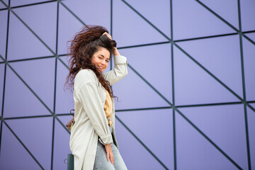 Smiling young stylish woman with curly hair