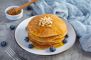 Delicious homemade pancakes with honey and blueberries. Tasty breakfast with crepes