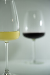 vasos de cristal sobre fondo blanco con reflejos, de vino blanco y vino tinto 