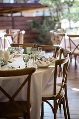 White table with tableware and chairs made of wood
