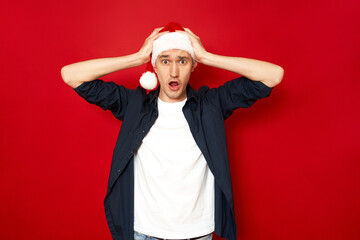 Omg Increadible unbelievable crazy discount gifts time Holly jolly xmas is soon Be ready prepare young shocked man are amazed with wide open eyes, mouth holding head with arms. isolated red background