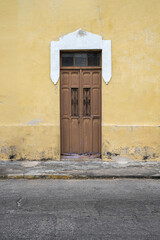 Distressed Yellow Wall with Wooden Door - 473028280