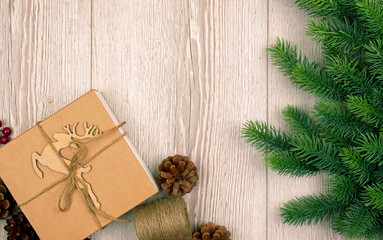 Christmas and New Year background with fir branches, holly,reindeer and gift on wooden  board. Flat lay. Top view.