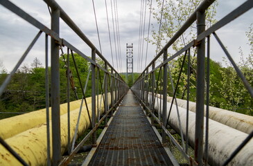 rusty iron bridge between large pipes