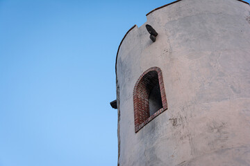 Old tower window with blue sky on background.