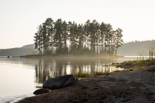 Sunset over the foggy lake.
