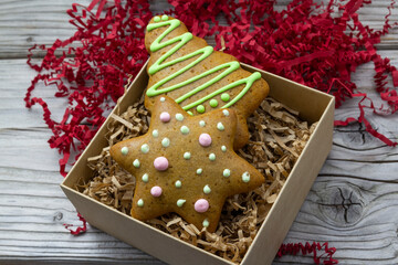 Christmas star gingerbread in gift box, red decoration wooden rustic background. Christmas background. New Year theme. Merry Christmas and Happy New Year Holidays greeting card, 