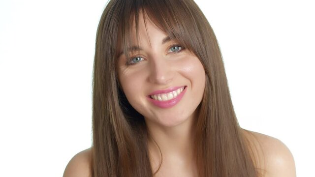 Smiling beautiful young woman with bared shoulders over white background. Concept of female beauty and healthy skin care.