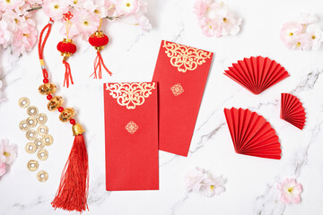 Chinese new year festival decoration. Traditional lunar new year red pockets, paper fans and gold ingots with text meaning fortune, prosperity, wealth. Flat lay, top view