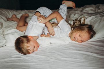 Children, brother and sister, hooligans, indulge, play in bed.