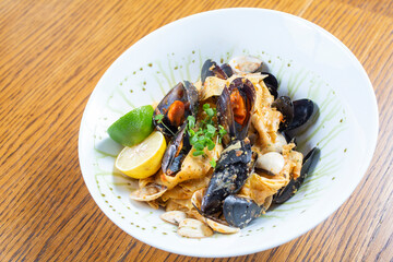 Tagliatelle with sea shells and spices in a white plate