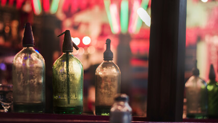 Close-up of vintage made soda siphons as decorative ornaments in a bar. Bokeh effect as background. 